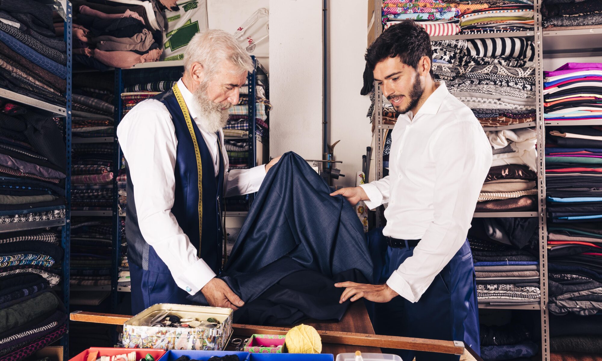 Two tailors working in a textile shop