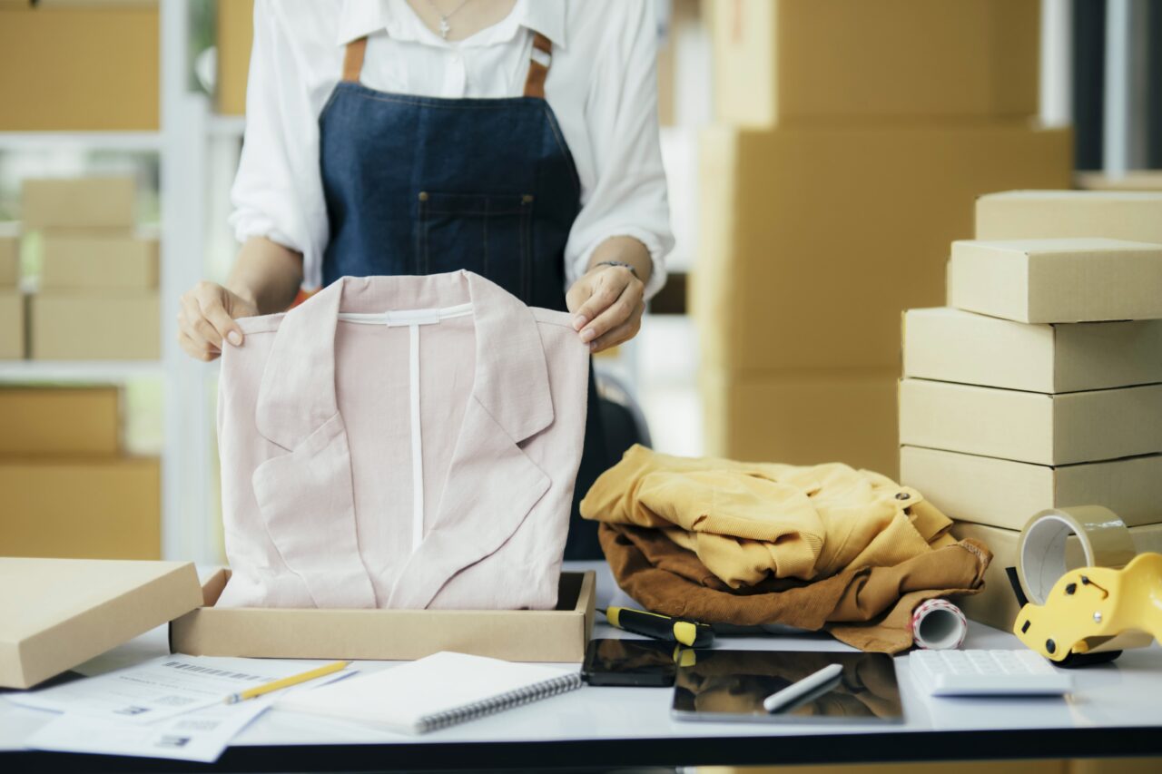 Small business owner packing clothing for despatch