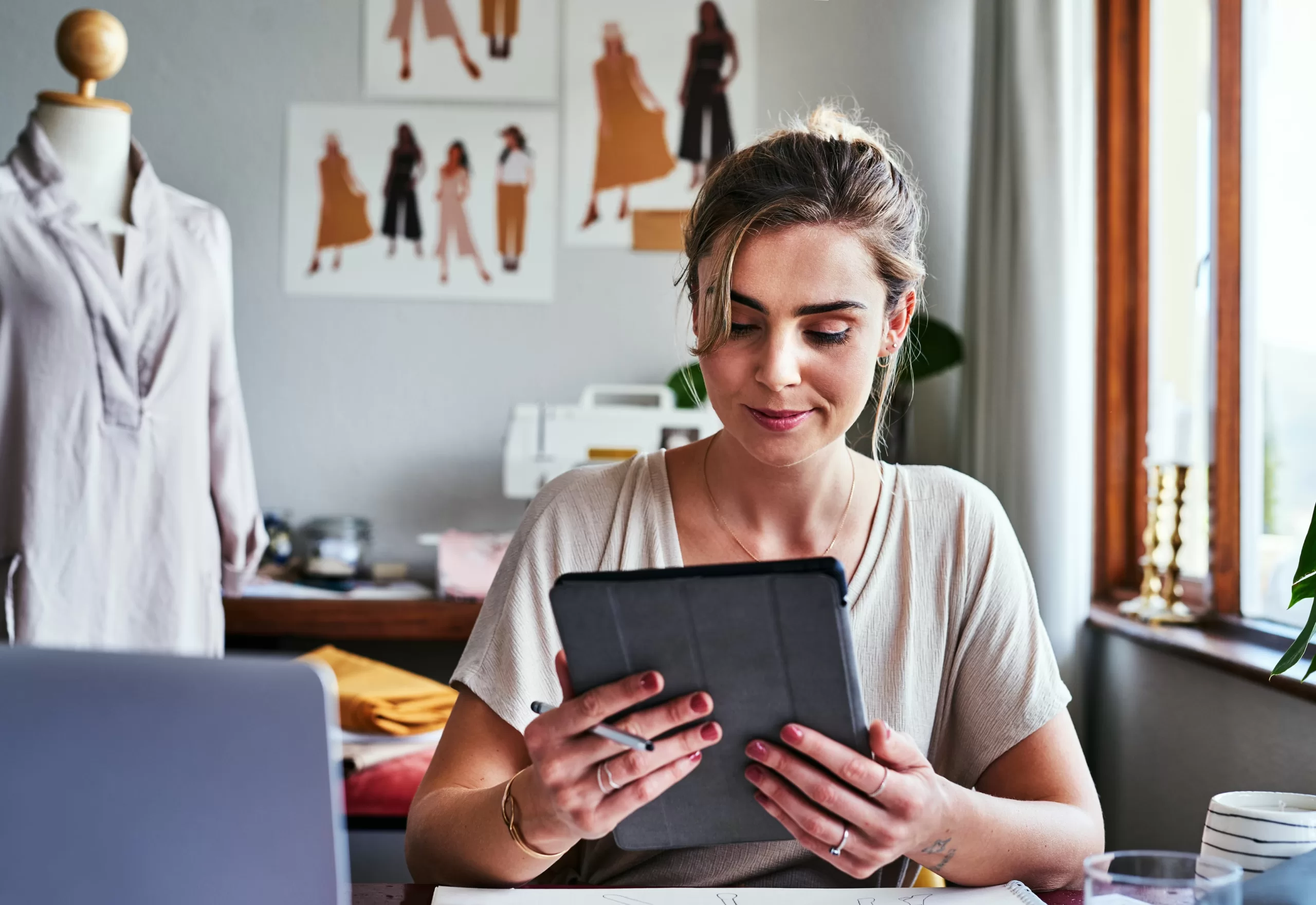 Woman using a sales app on her tablet while in the studio.