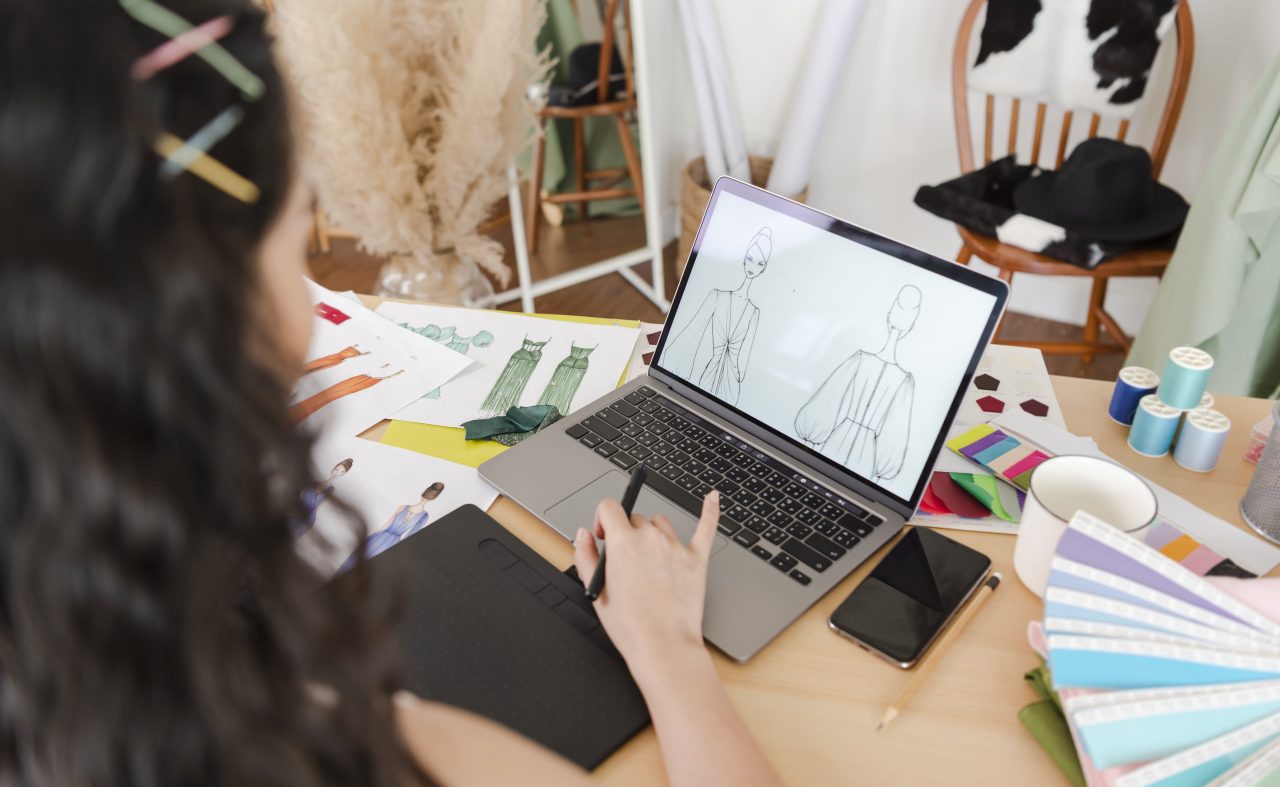 Designer using laptop for fashion sketches
