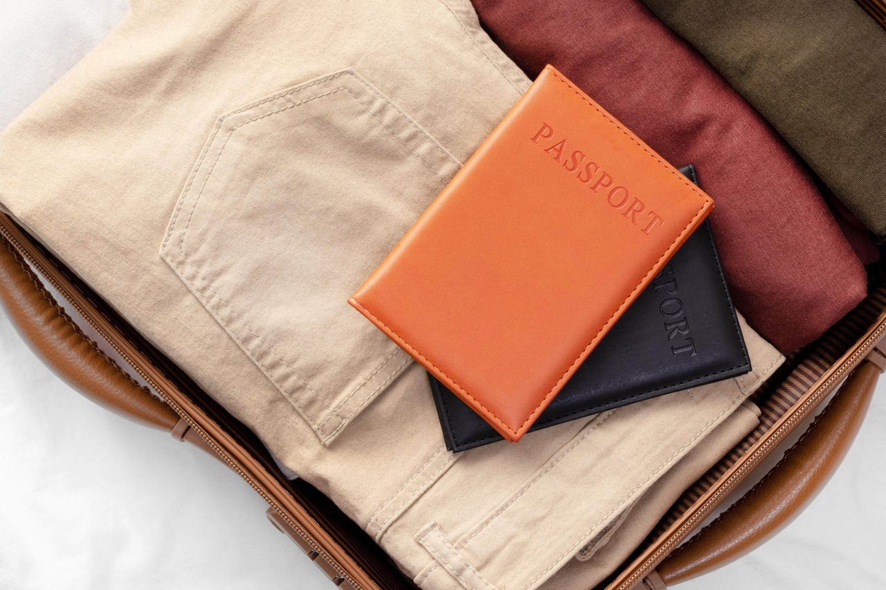 Opened luggage with folded clothes and passport