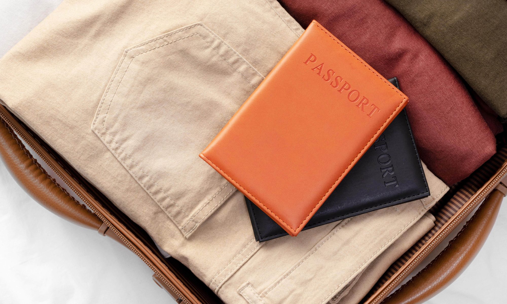 Opened luggage with folded clothes and passport